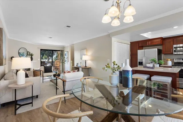 a living room with furniture a chandelier and a dining table