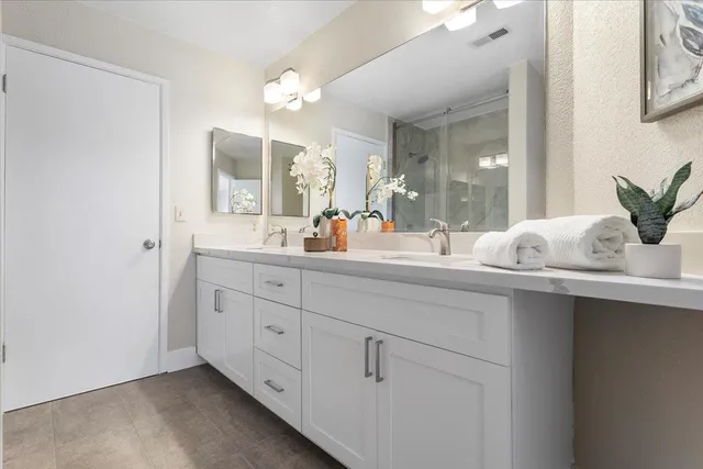a bathroom with double vanity sink and a mirror