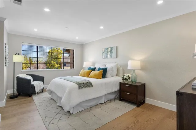 a spacious bedroom with a bed a couch and a large window