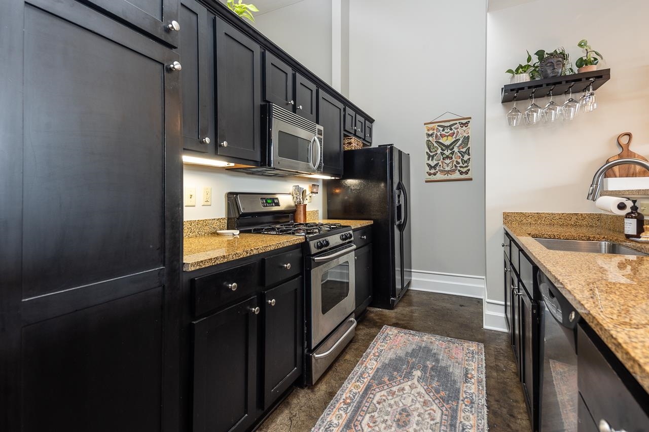 648 Riverside Drive, Unit 213 Memphis, TN 38103 - Photo 9 of 25 a kitchen with stainless steel appliances granite countertop a stove a sink and a refrigerator