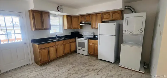 a kitchen with a refrigerator a stove top oven and cabinets