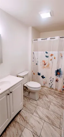 a white toilet sitting next to a bathroom sink