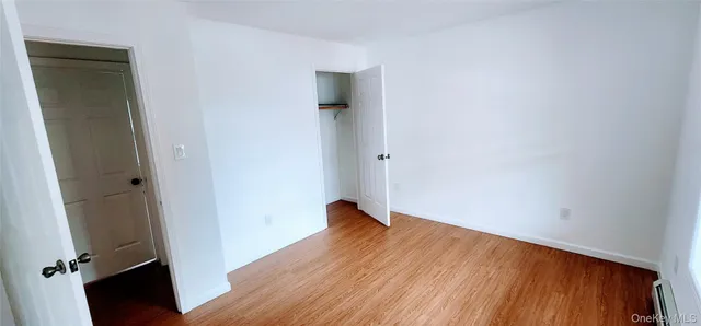 an empty room with wooden floor and closet