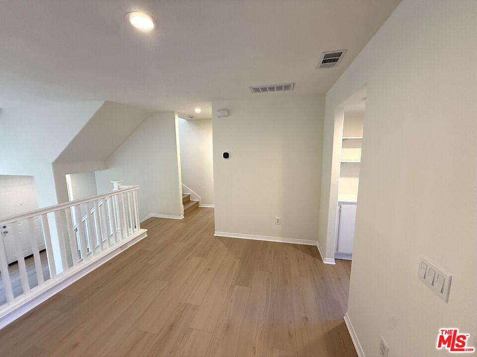 25715 Wagner Way, Unit B Stevenson Ranch, CA 91381 - Photo 16 of 24 a view of a hallway with wooden floor