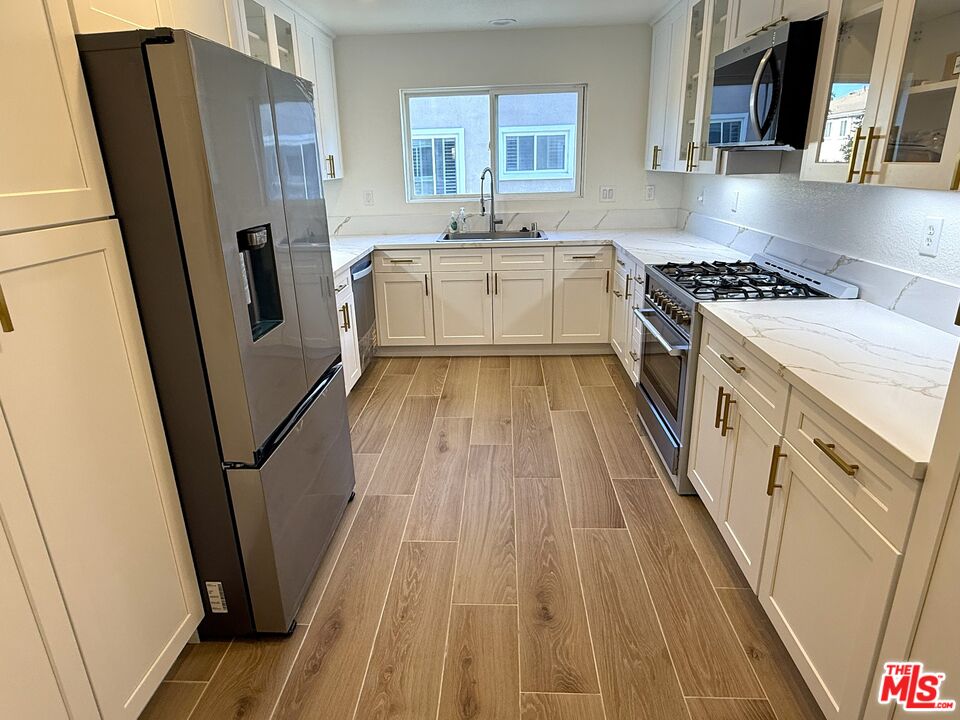 25715 Wagner Way, Unit B Stevenson Ranch, CA 91381 - Photo 8 of 24 a kitchen with white cabinets and white appliances