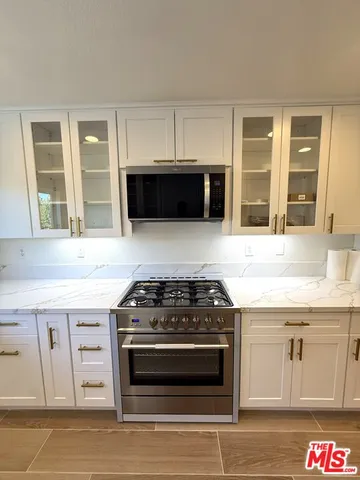 a kitchen with stainless steel appliances granite countertop a stove and a microwave