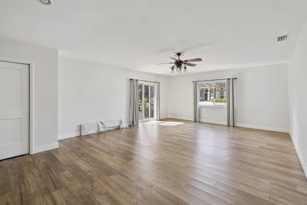 a view of an empty room with wooden floor