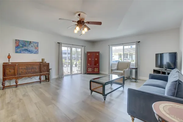 a living room with furniture and a dining table with wooden floor