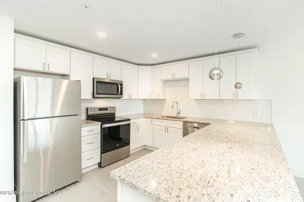 a kitchen with a refrigerator sink stove and cabinets