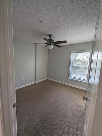 a view of a livingroom with a ceiling fan and window