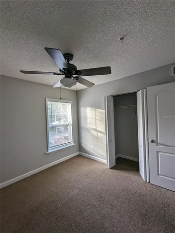 a view of a livingroom with a ceiling fan and window