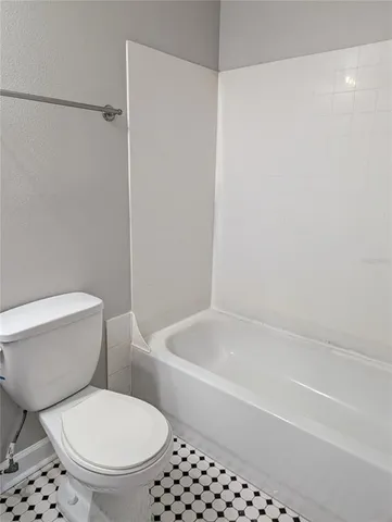a white toilet sitting next to a bath tub