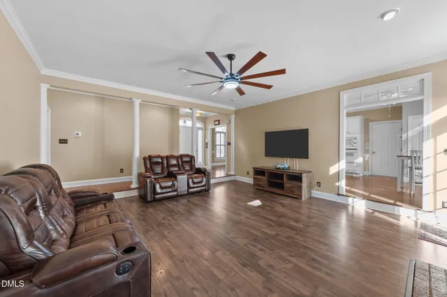 a living room with furniture and a flat screen tv with wooden floor