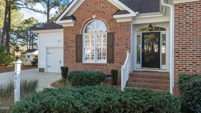 a front view of a house with plants