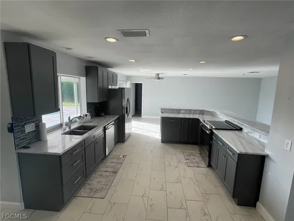 a kitchen with stainless steel appliances granite countertop a sink a stove and a refrigerator