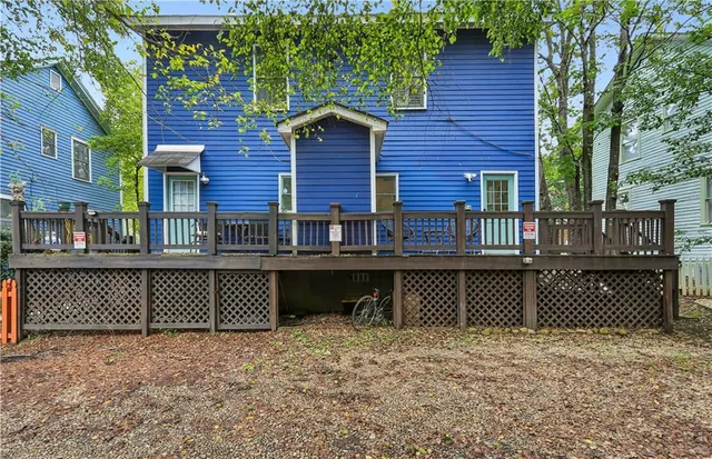 a front view of a house with a yard and a large tree