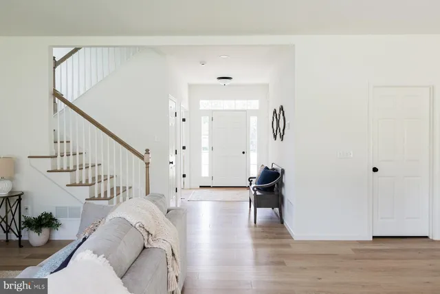 a living room with wooden floor and stairs