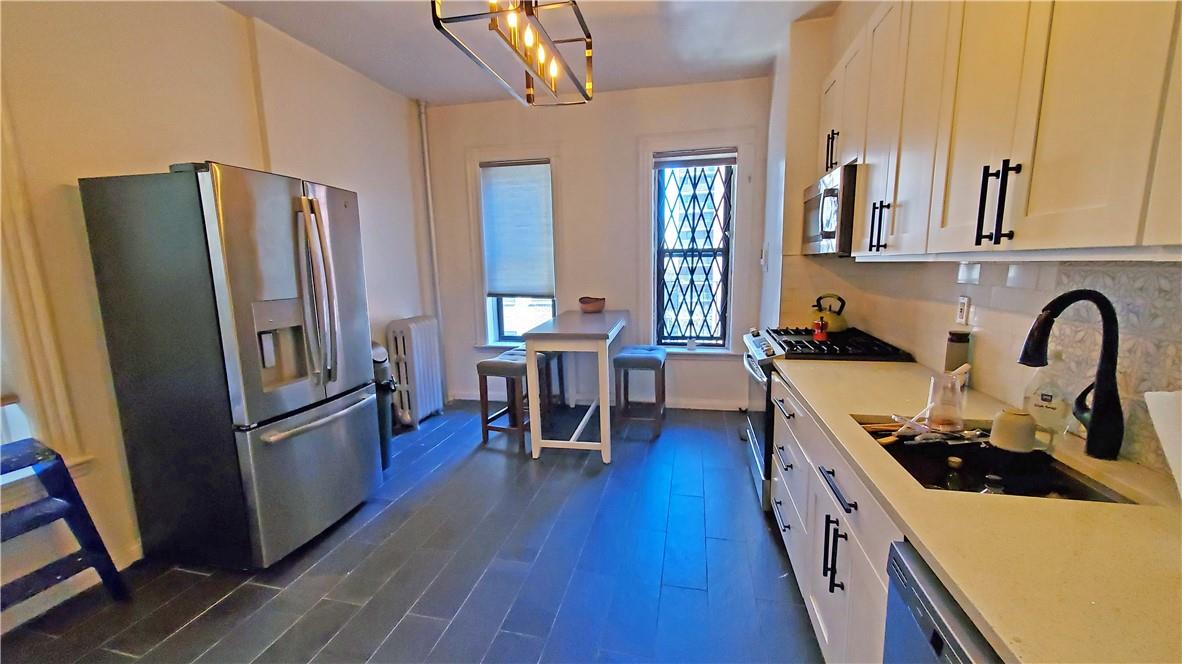 a kitchen with stainless steel appliances granite countertop a refrigerator stove and sink