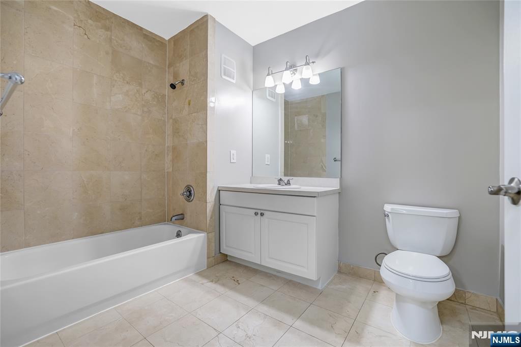 905 River Road, Unit 309 Edgewater, NJ 07020 - Photo 14 of 32 a bathroom with a toilet sink and mirror