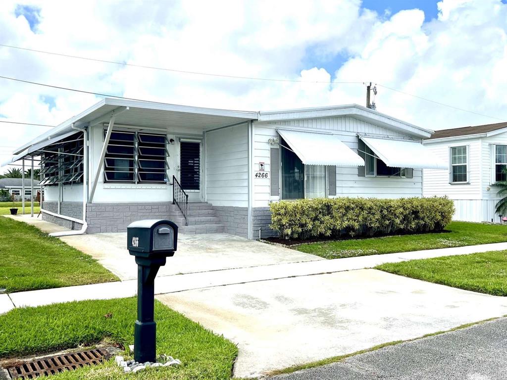 4266 Bob White Drive Boynton Beach, FL 33436 - Photo 1 of 24 a front view of a house with garden and plants