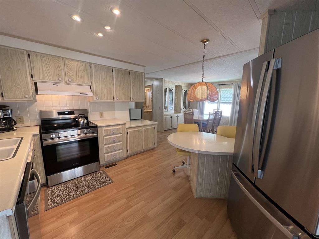 4266 Bob White Drive Boynton Beach, FL 33436 - Photo 12 of 24 a kitchen with stainless steel appliances a stove a sink dishwasher a refrigerator white cabinets and wooden floor