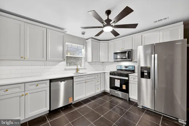 a kitchen with cabinets stainless steel appliances a sink and cabinets