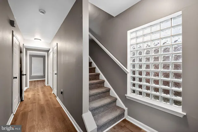 a view of a hallway with wooden floor and stairs