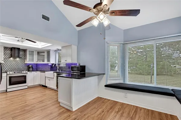 a kitchen with stainless steel appliances a stove top oven and a chandelier
