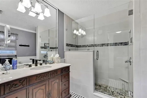 a bathroom with a sink vanity granite and shower