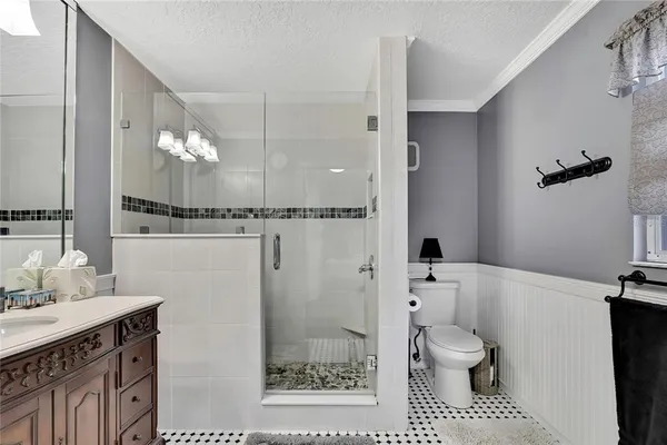 a bathroom with a sink a toilet a mirror and shower