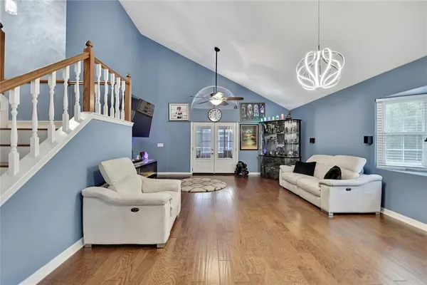a living room with furniture chandelier and a wooden floor