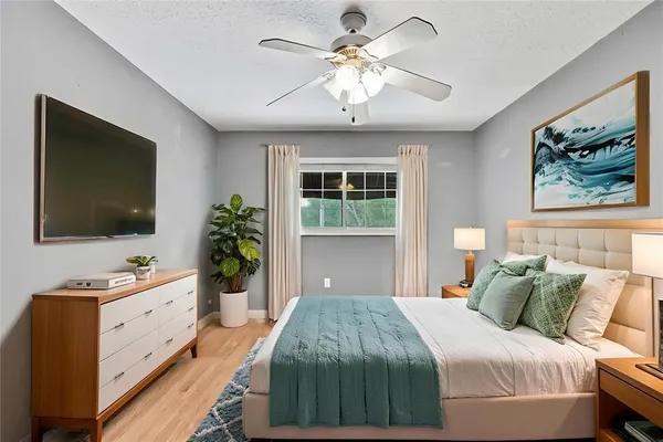a bedroom with a large bed and a flat tv screen on dresser