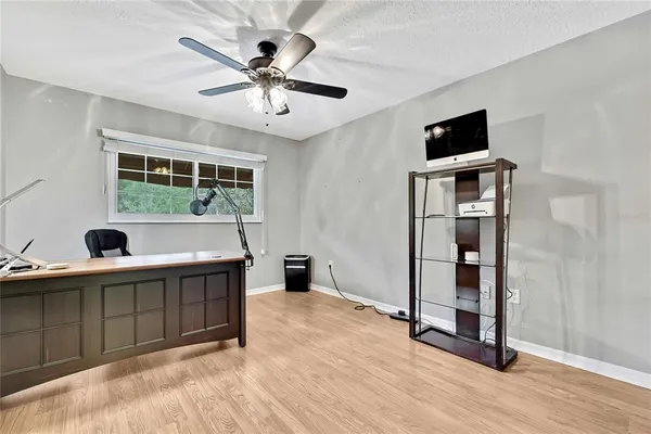 a view of workspace with wooden floor and ceiling fan