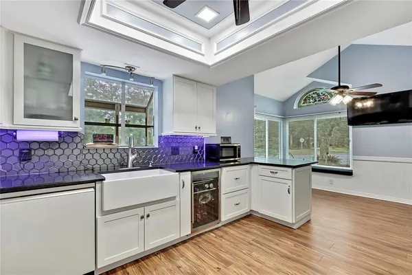 a kitchen with granite countertop a stove a sink and dishwasher with wooden floor