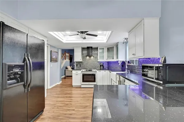 a kitchen with stainless steel appliances kitchen island granite countertop a refrigerator and a stove