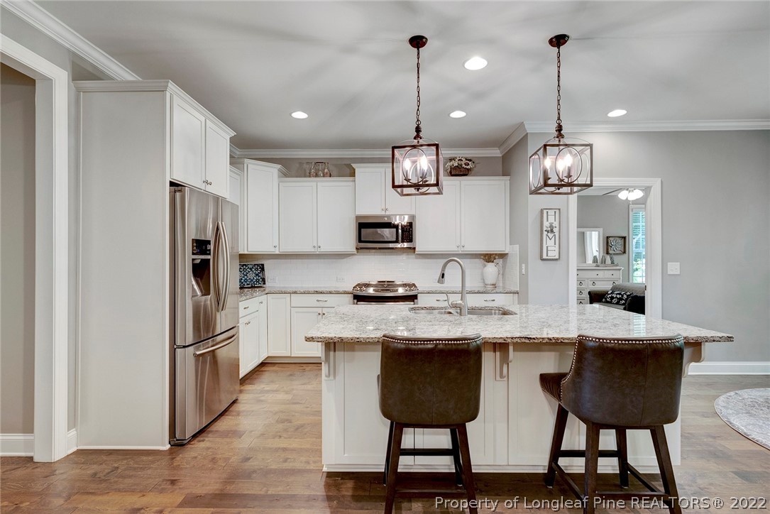 4139 Olde Judd Drive Willow Spring, NC 27592 - Photo 14 of 42 a kitchen with kitchen island granite countertop a sink a center island and stainless steel appliances