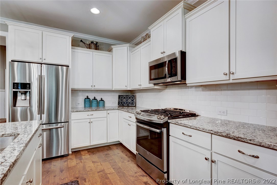 4139 Olde Judd Drive Willow Spring, NC 27592 - Photo 17 of 42 a kitchen with granite countertop white cabinets and stainless steel appliances
