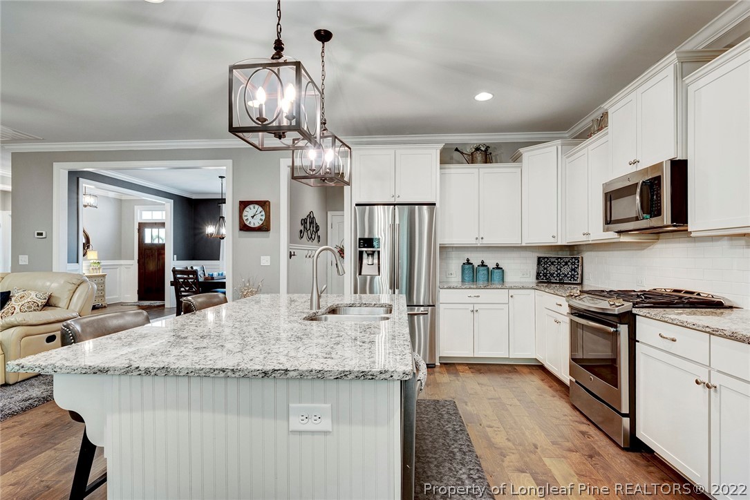 4139 Olde Judd Drive Willow Spring, NC 27592 - Photo 18 of 42 a kitchen with kitchen island granite countertop a table and chairs in it