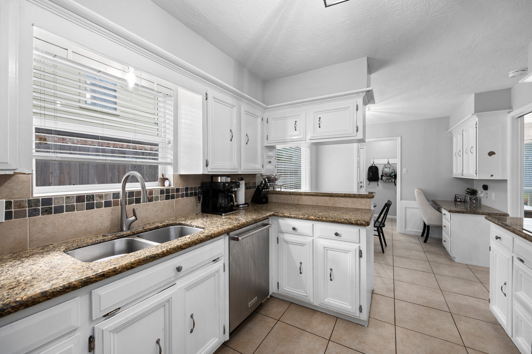 9123 Herts Road Spring, TX 77379 - Photo 17 of 40 The kitchen is filled with natural light and features an undercount sink, SS appliances, breakfast bar, and built in desk.