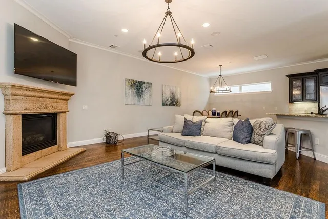 a living room with furniture a flat screen tv and kitchen view