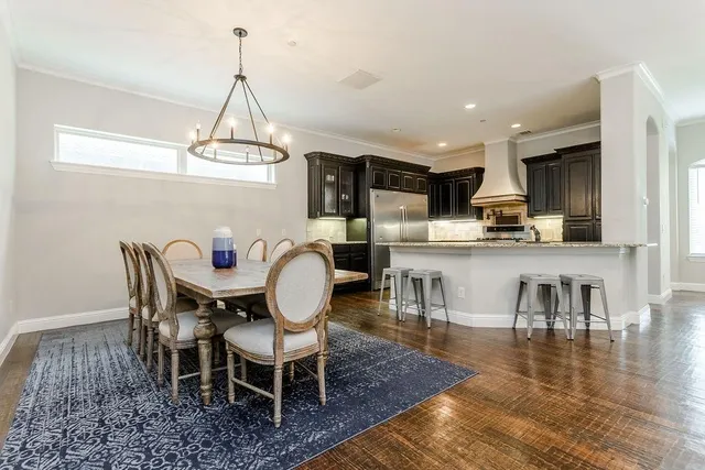 a dining room with furniture a chandelier and wooden floor