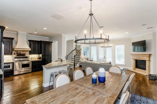 a kitchen with stainless steel appliances granite countertop a stove and a wooden floor