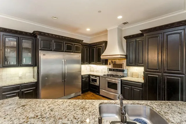 a kitchen with stainless steel appliances granite countertop a stove a sink and a refrigerator