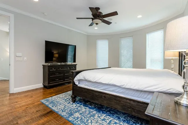 a spacious bedroom with a bed and a television