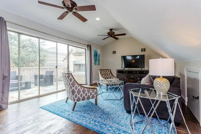 a living room with furniture a flat screen tv and a large window