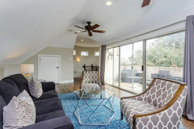a living room with furniture and a floor to ceiling window