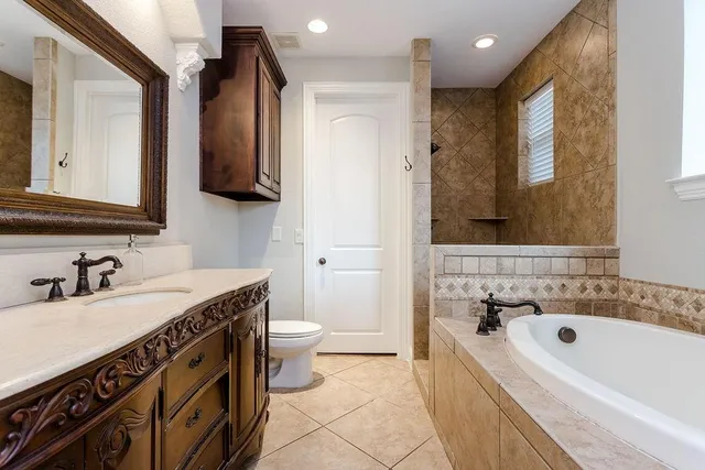 a bathroom with a sink a toilet a mirror and bathtub