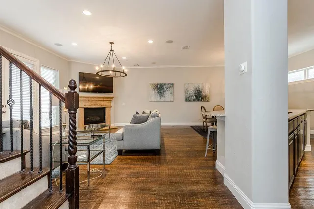 a living room with furniture a fireplace and a chandelier