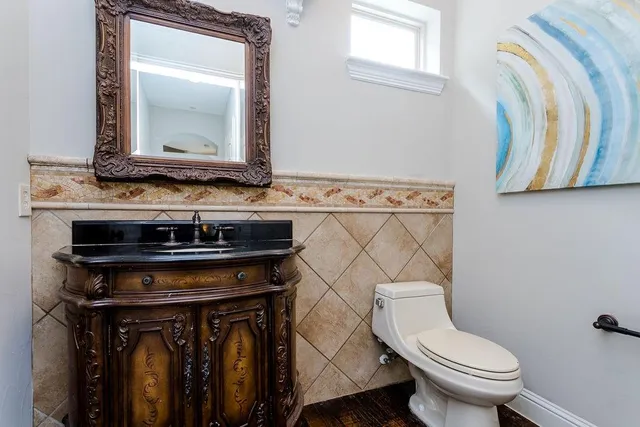 a bathroom with a toilet a sink and a mirror