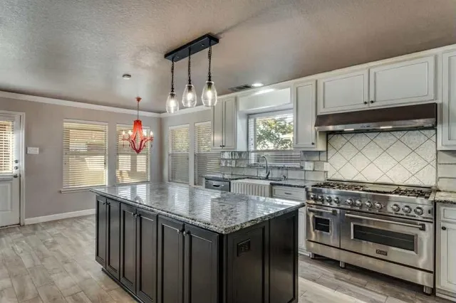 a kitchen with granite countertop a stove and a sink